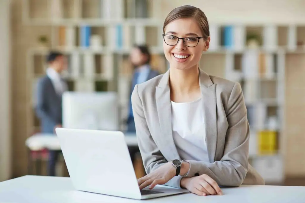 Happy young businesswoman in formalwear looking at camera